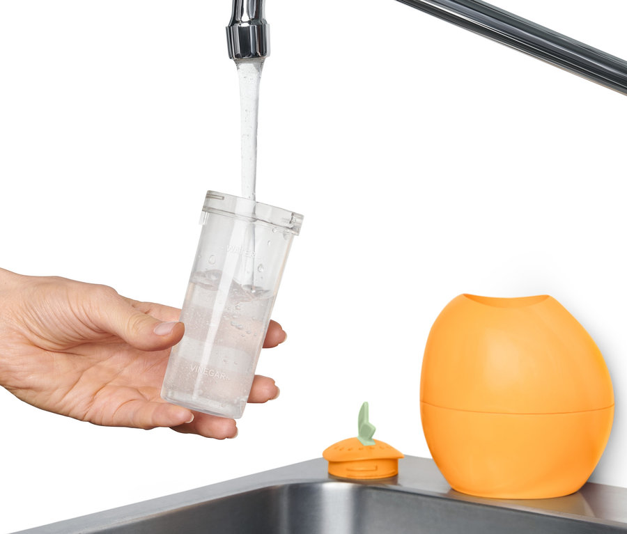 Eine Hand befüllt einen Mikrowellenreiniger mit Wasser.