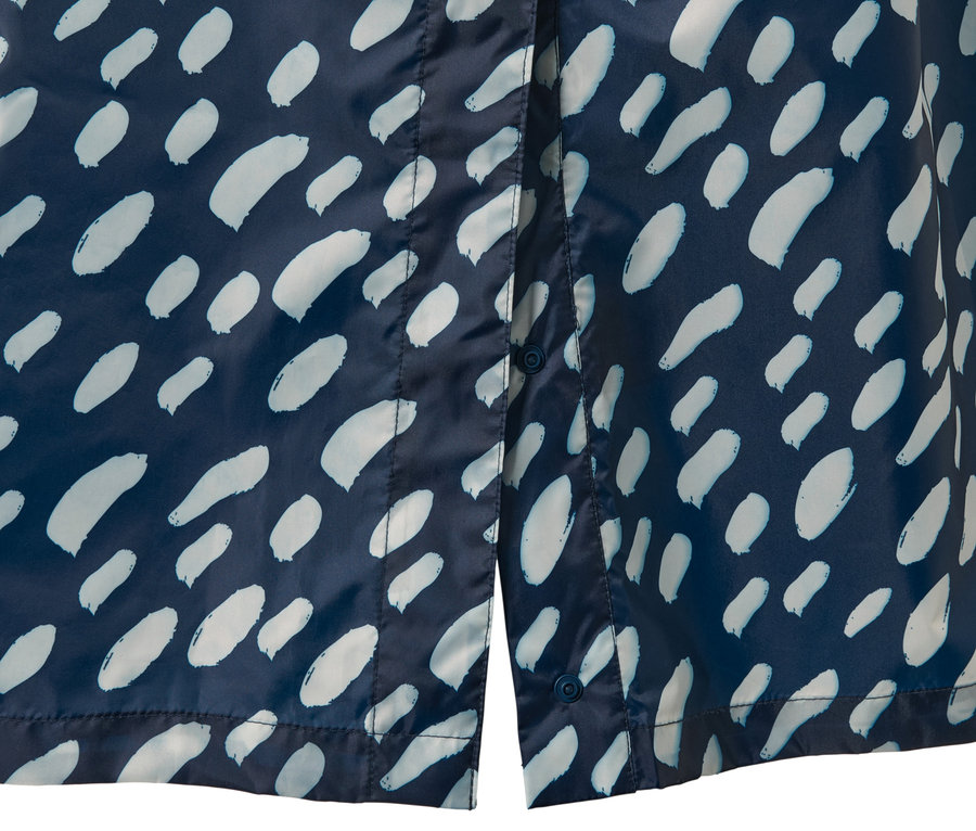 Detailansicht eines blauen Regenponchos mit Ärmeln und hellem Muster.