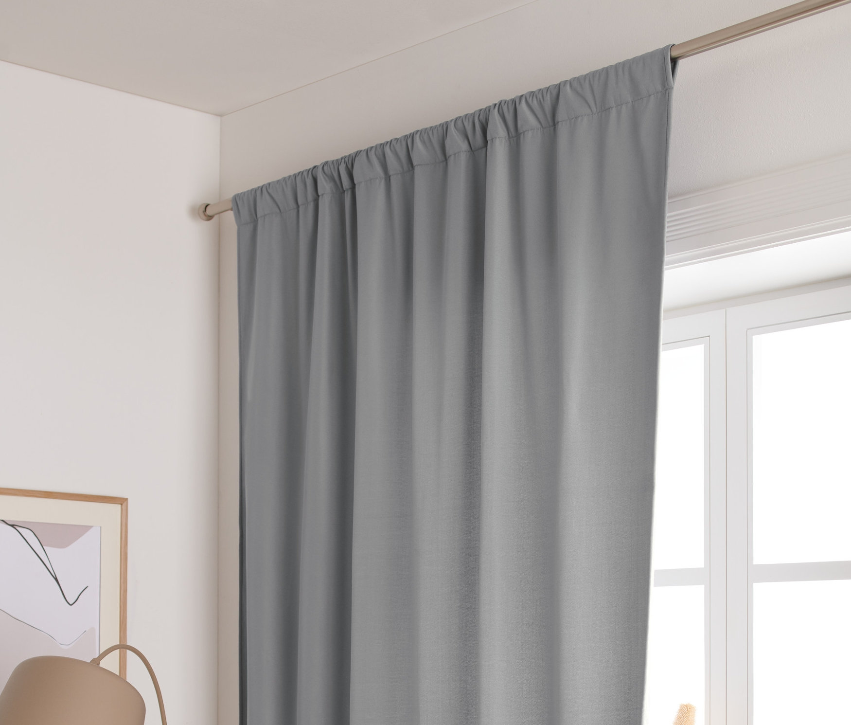 Grauer Thermovorhang hängt am Fenster.