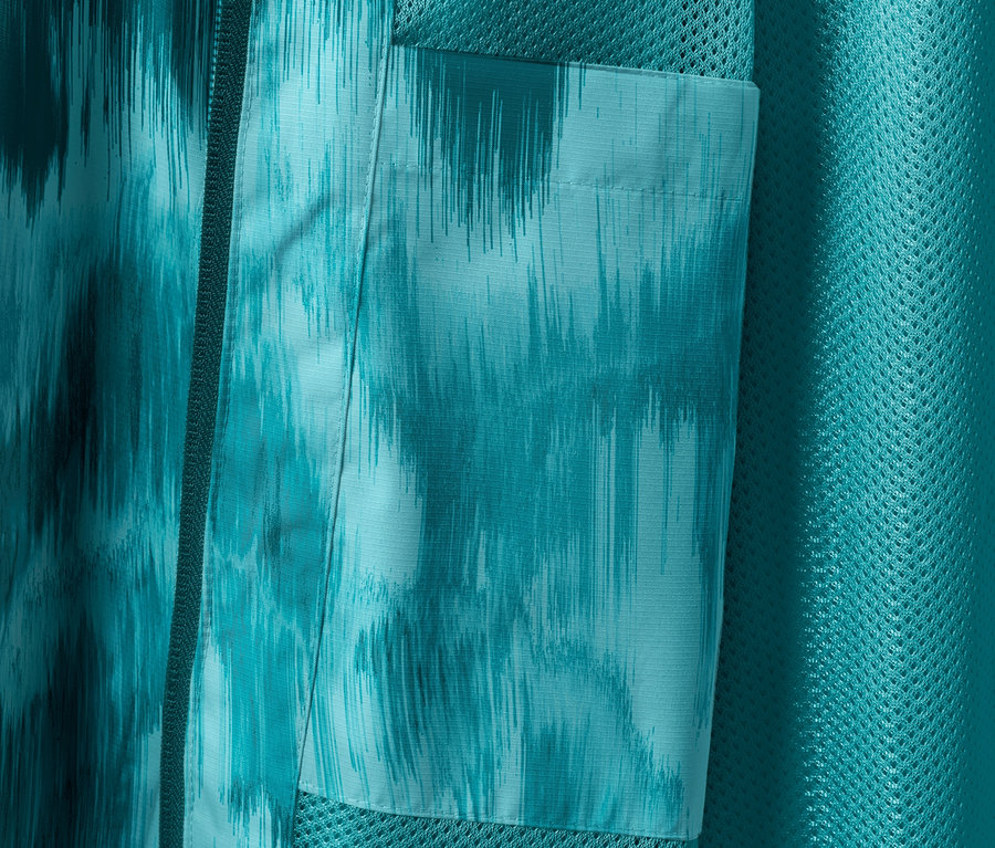 Detail einer Regenjacke mit Alloverprint und Tasche.
