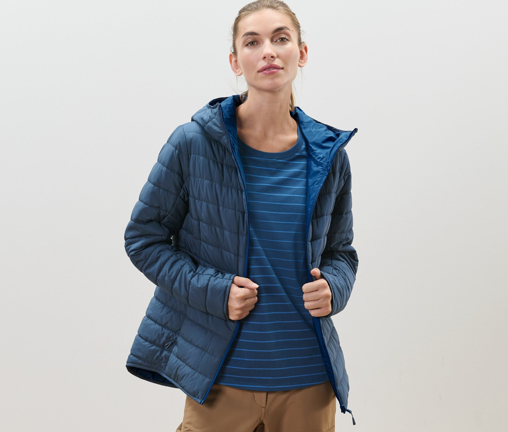 Frau trägt eine blaue, wasserdichte Wende-Steppjacke.