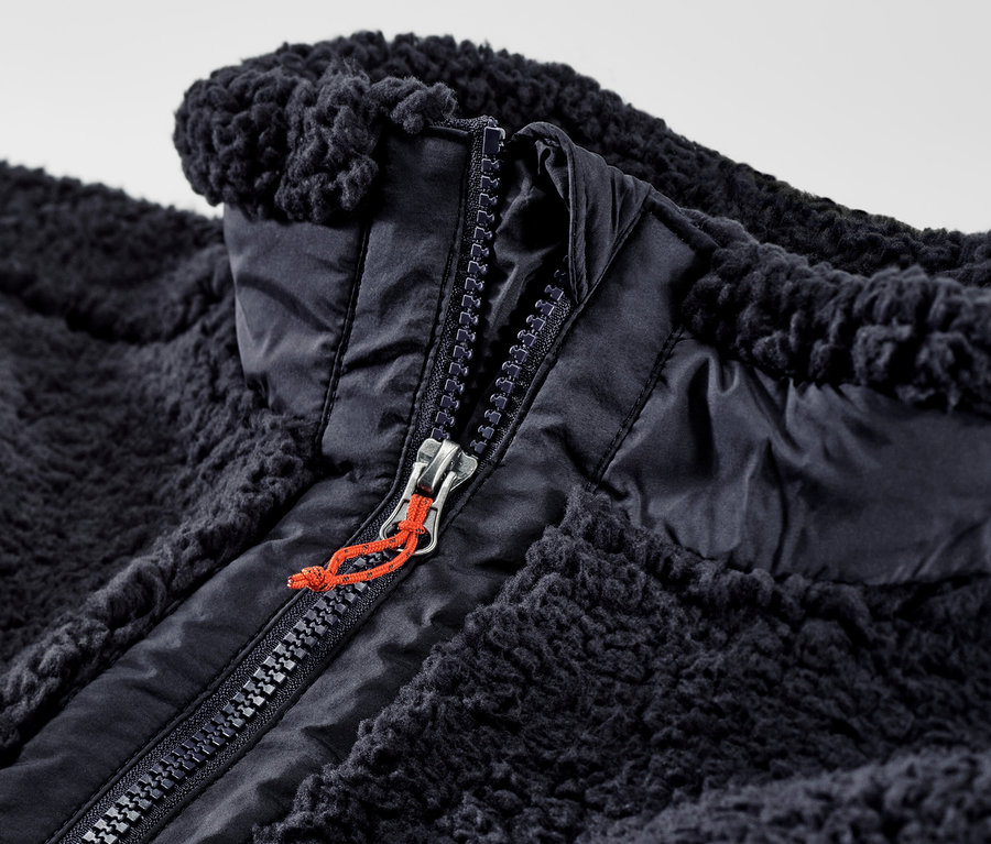 Nahaufnahme einer offenen Teddy-Weste mit Reißverschluss.