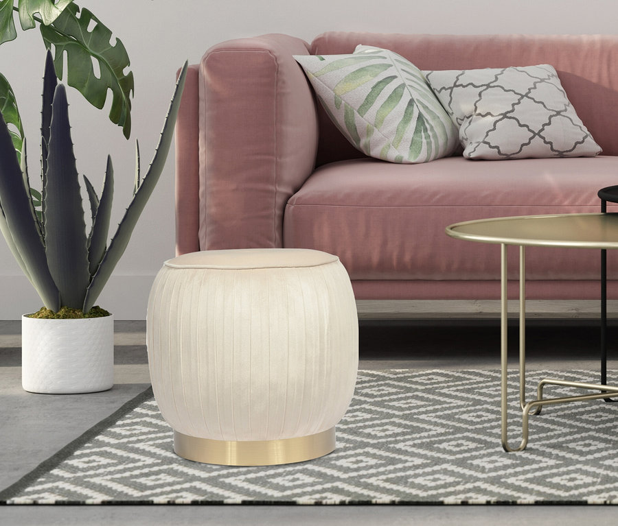 Ein beiger Kayoom Hocker Lilje steht im Wohnzimmer vor einem rosa Sofa.