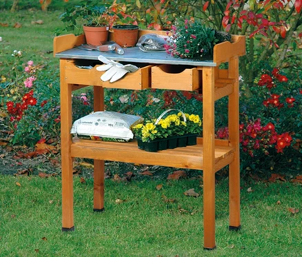 Pflanztisch mit Schubladen mit Pflanzen, Blumen, Handschuhen und Werkzeugen im Garten.