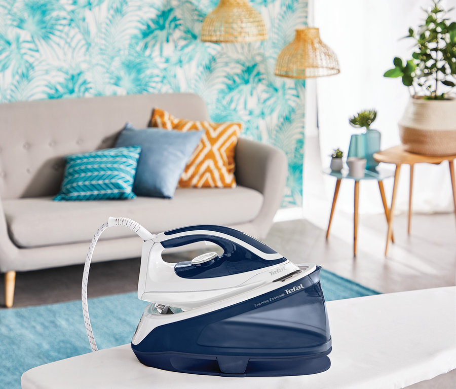 Auf einem Bügelbrett steht eine blau-weiße Tefal Dampfbügelstation »Express Essential«.