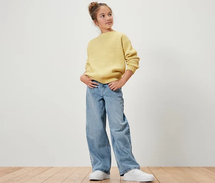 Mädchen posiert in gelbem Pullover und Kinder-Jeans ‒ Fit »Lena«.