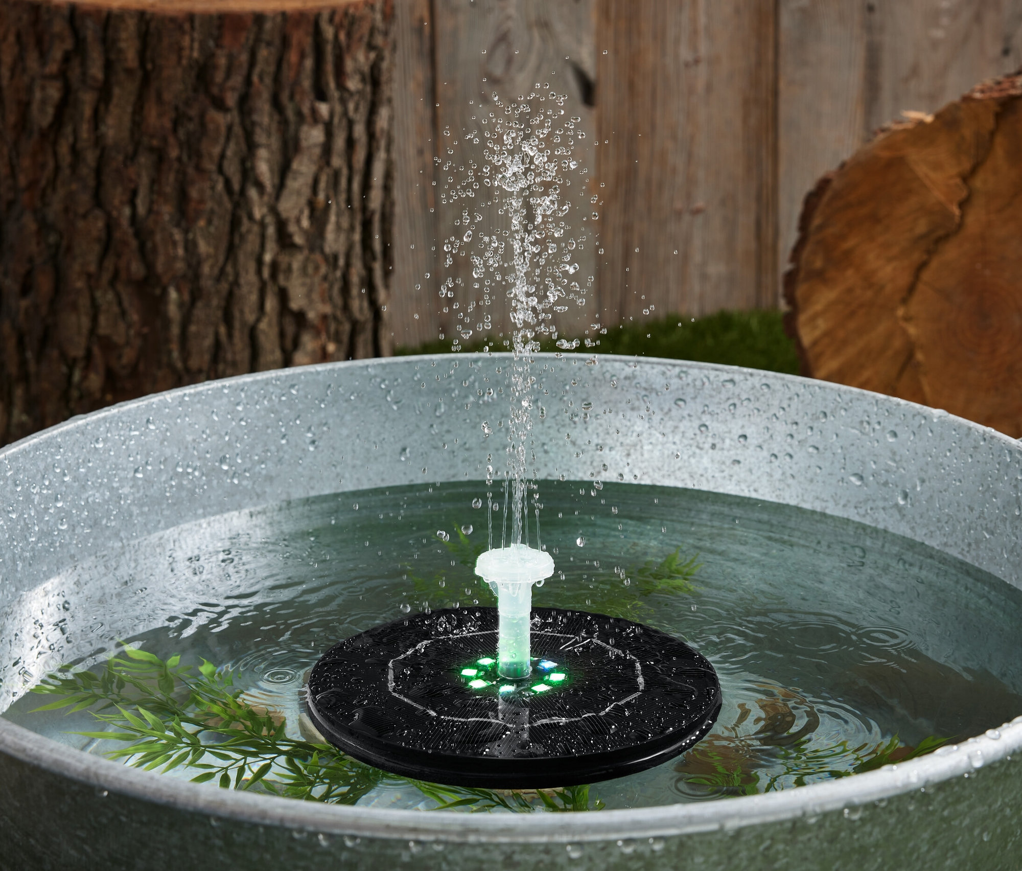 Schwimmender Solar-Springbrunnen mit Beleuchtung in einer Wanne mit Wasser.