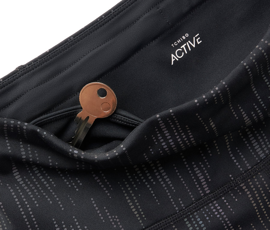 Detail einer schwarzen Tchibo Active Leggings mit einem Schlüssel in der Tasche.