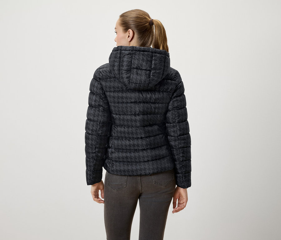 Frau von hinten trägt eine schwarze Daunenjacke mit Kapuze im Hahnentrittmuster.