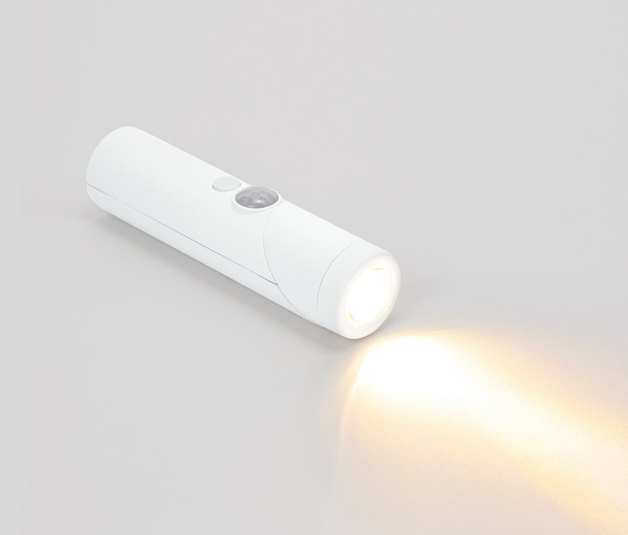 Eine weiße Taschenlampe leuchtet auf einem grauen Hintergrund.