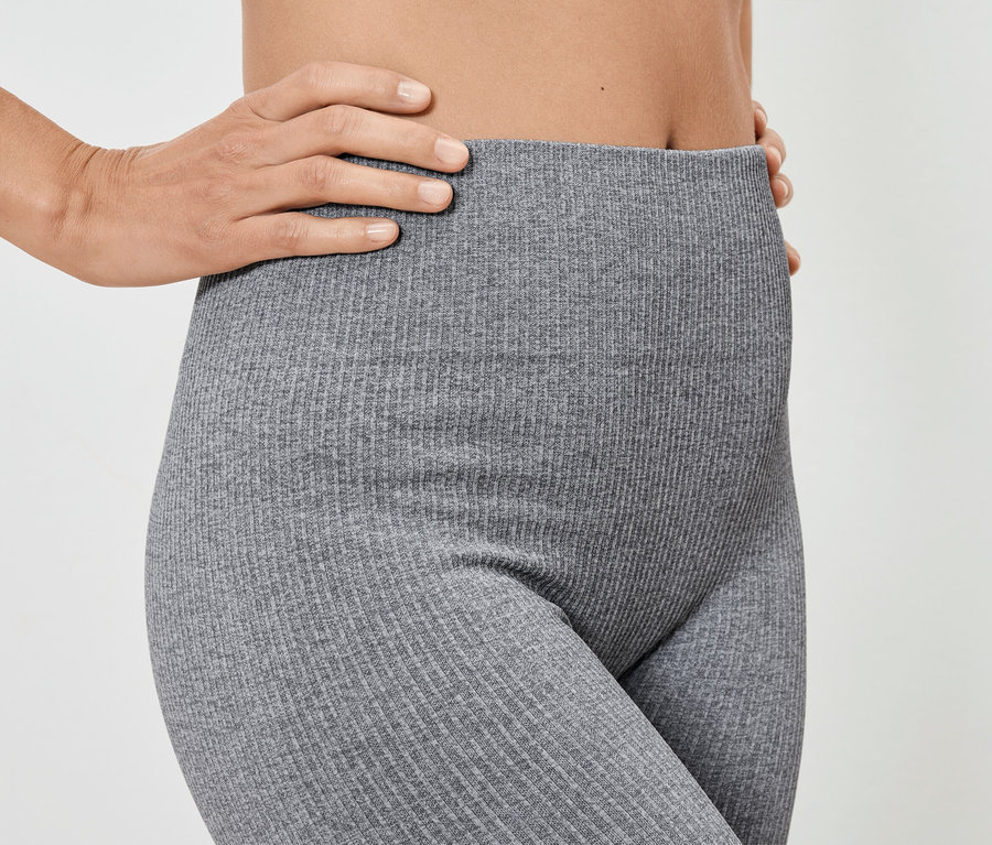 Frau posiert in grauen gerippten Leggings.