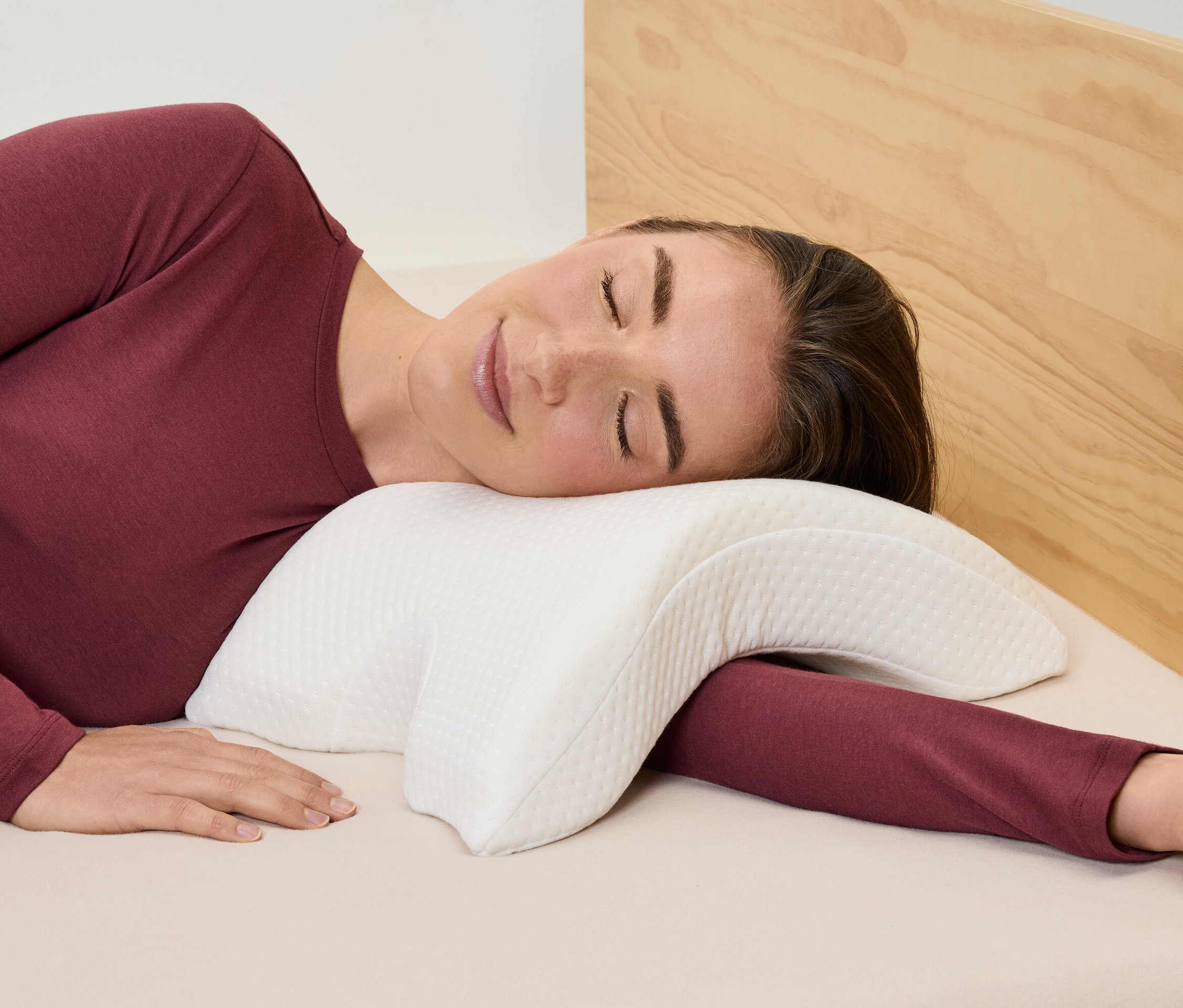 Frau liegt seitlich auf einem weißen Kissen.