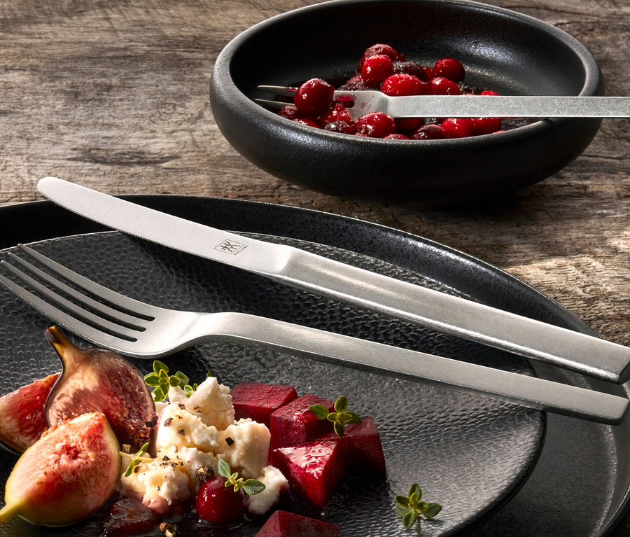 Teller mit Feigen, Rüben und Käse mit ZWILLING Vintage-Besteck, gehämmert, 60-teilig. Schale mit Preiselbeeren mit Gabel.