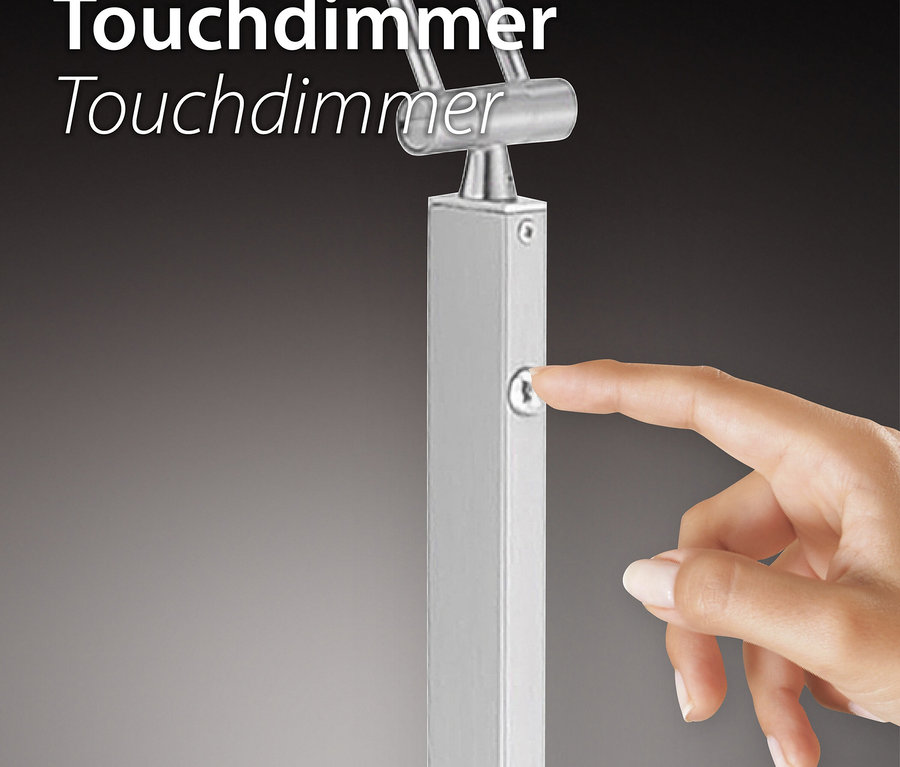 Ein Finger berührt einen Touchdimmer an einer silberfarbenen Lampe.