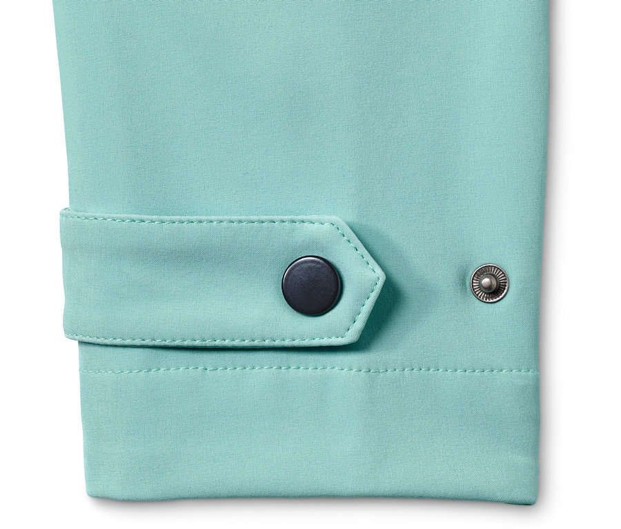 Detailansicht eines türkisfarbenen Softshellmantels mit Druckknöpfen.