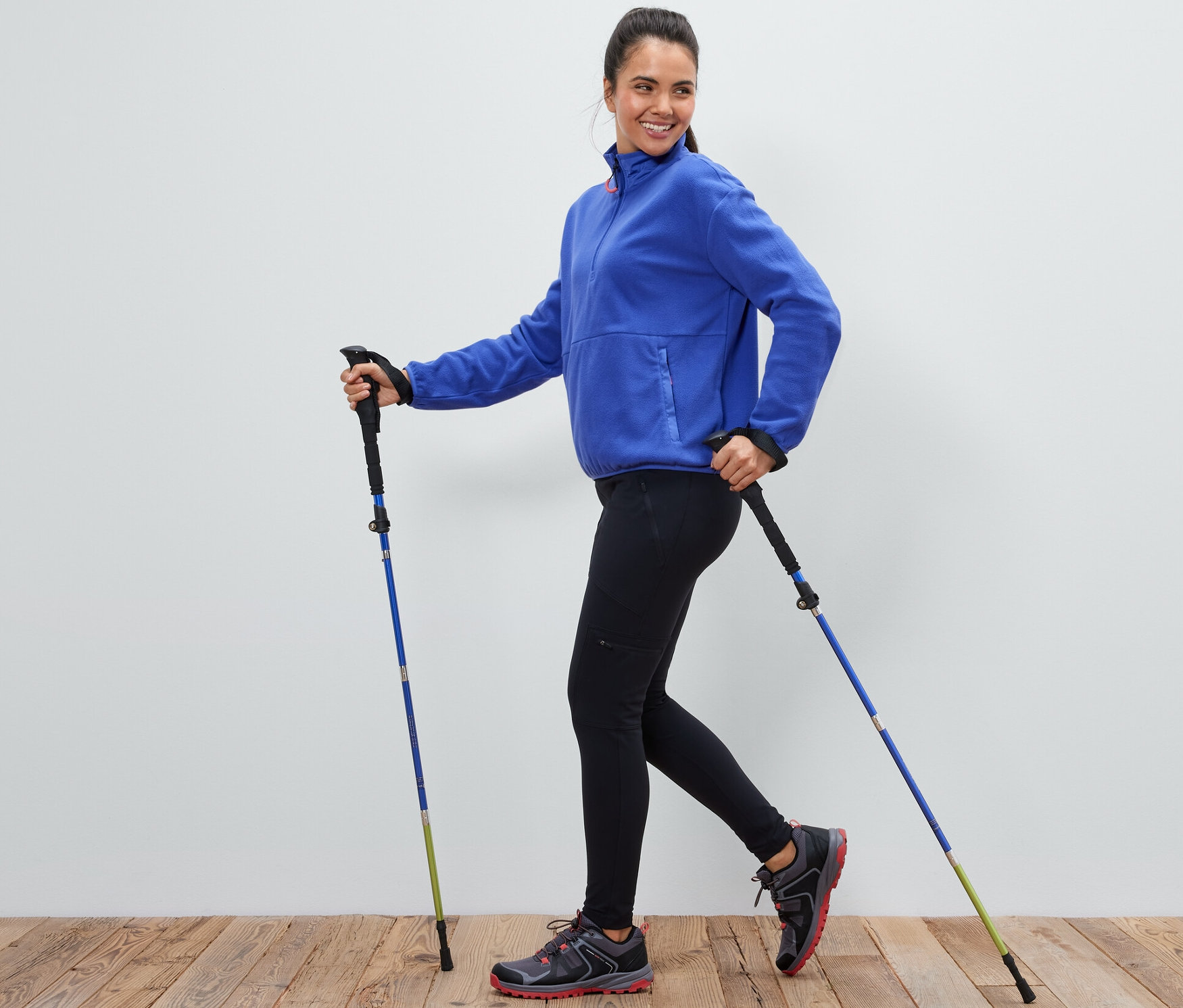 Frau benutzt 1 Paar Falt-Trekkingstöcke.