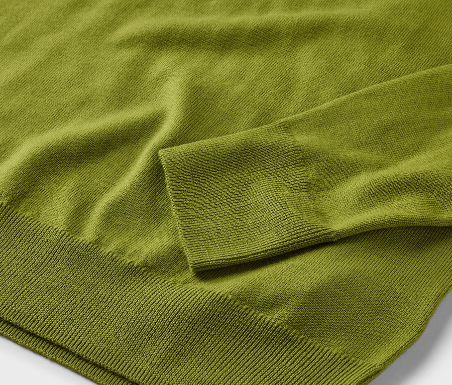 Detailaufnahme eines hellgrünen Merino-Feinstrickpullovers.