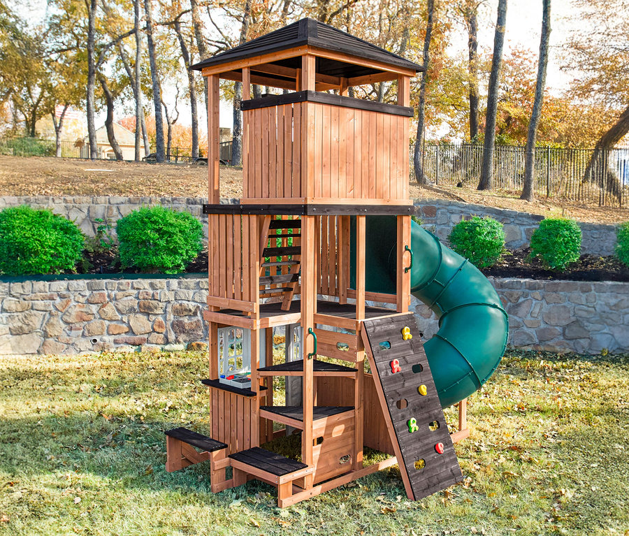 Außenansicht des Spielturms »Ramba« mit Rutsche, Kletterwand und Leiter in einem Garten.