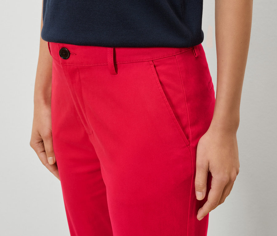 Nahaufnahme einer Frau, die rote Hosen und ein blaues Hemd trägt.