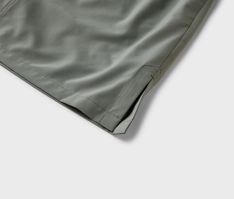 Nahaufnahme der olivgrünen Stoffhose mit Seitentasche.
