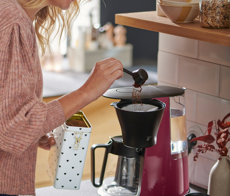 Frau mit blonden Haaren füllt Kaffee in eine »Let's Brew« Filterkaffeemaschine, berry.