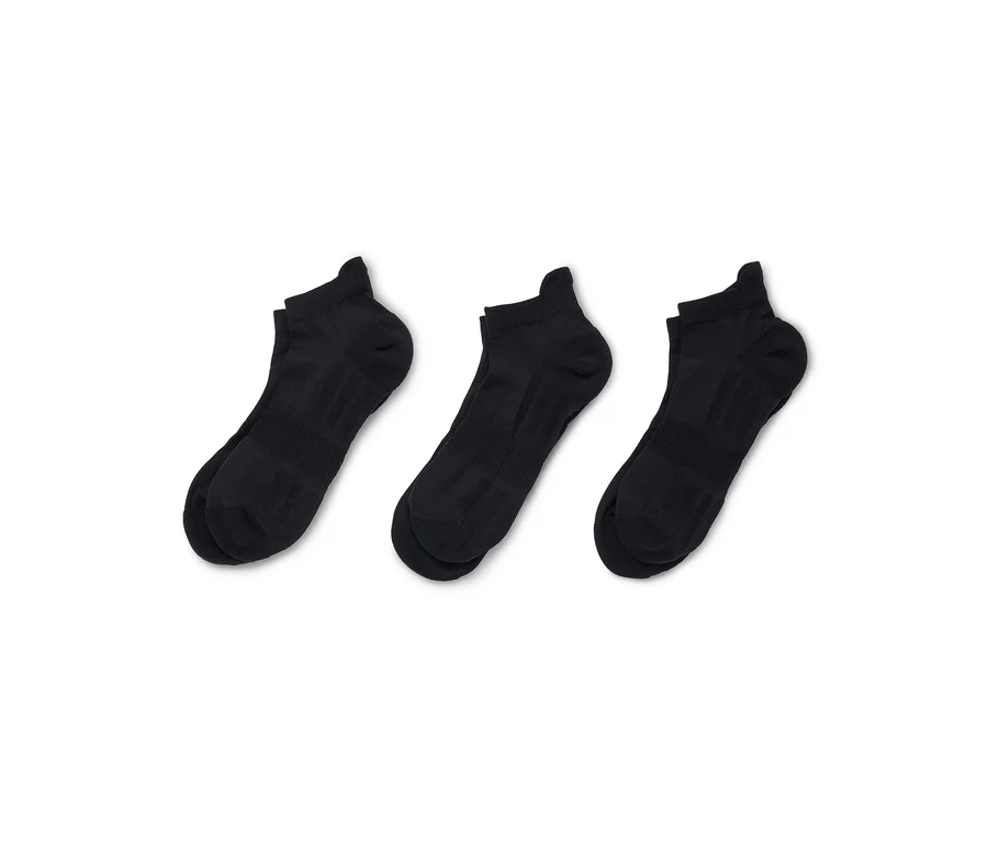 Drei schwarze Knöchelsocken sind diagonal auf einem weißen Hintergrund angeordnet.