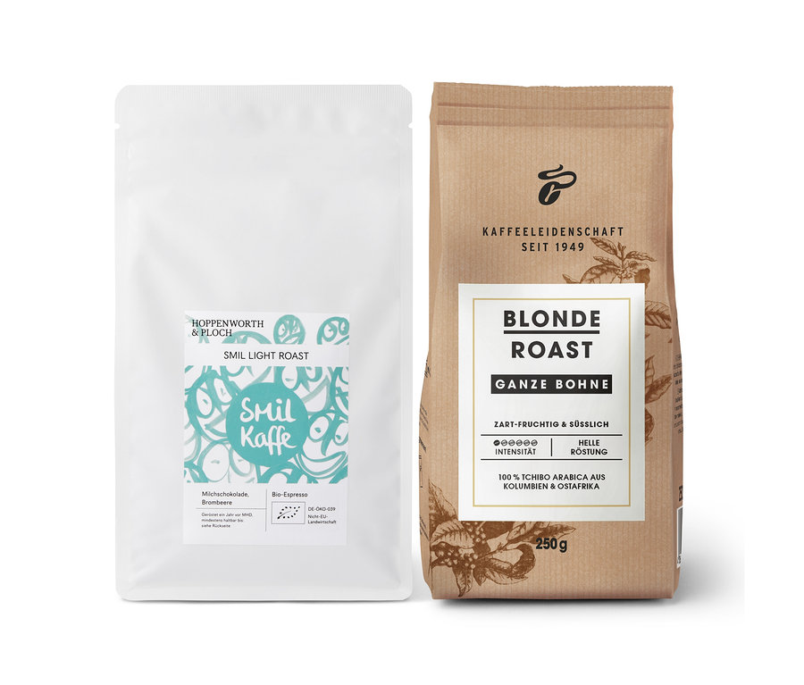 Eine weiße Packung Smil Kaffe Light Roast und eine braune Packung Blonde Roast Kaffee, ganze Bohne, stehen nebeneinander.