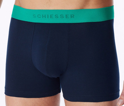 Mann trägt dunkelblaue Boxershorts mit grünem SCHIESSER Bund.