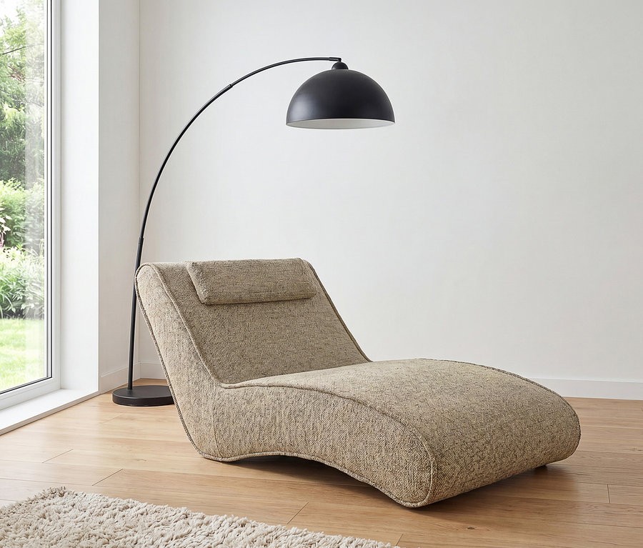 Beige strukturierte Récamiere mit Kopfstütze, eine schwarze Bogenstehlampe und ein heller Hochflorteppich auf Holzboden an einem Fenster mit Gartenblick.