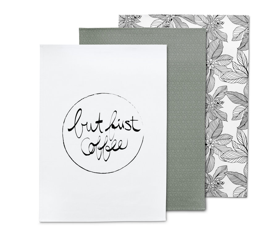 Ein Set aus 3 Geschirrtüchern: ein weißes mit der Aufschrift "but first coffee", ein graugrünes mit geometrischem Muster und ein weißes mit schwarzen Blättern.
