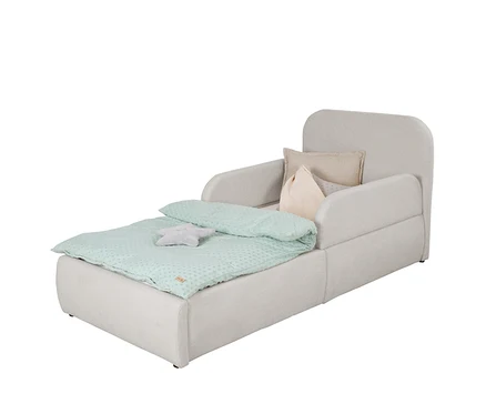 Helles beiges Kindersofa, das zu einem Bett ausgezogen ist, mit einer mintgrünen gepunkteten Decke, einem grauen Sternkissen und zwei weiteren Kissen (beige und hellrosa) am Kopfteil.