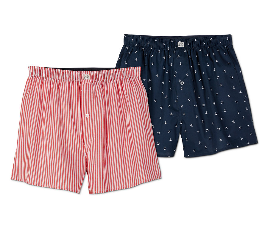 Zwei Web-Boxershorts, eine rot-weiß gestreift, die andere dunkelblau mit Anker-Muster.