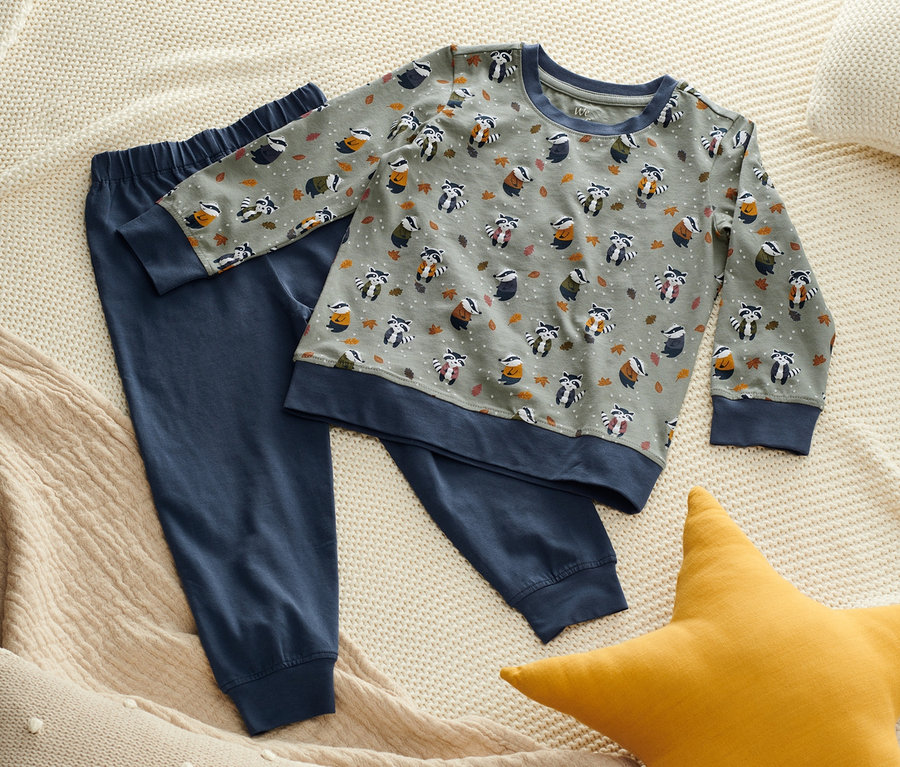 Ein Pyjama-Set mit Dachs-Print liegt auf einem Bett.