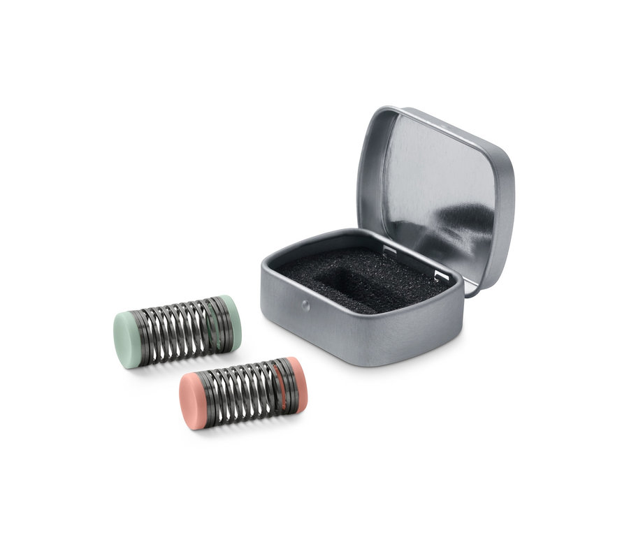 Zwei Mini-Gesichtsepilierer neben einer geöffneten silbernen Schachtel.