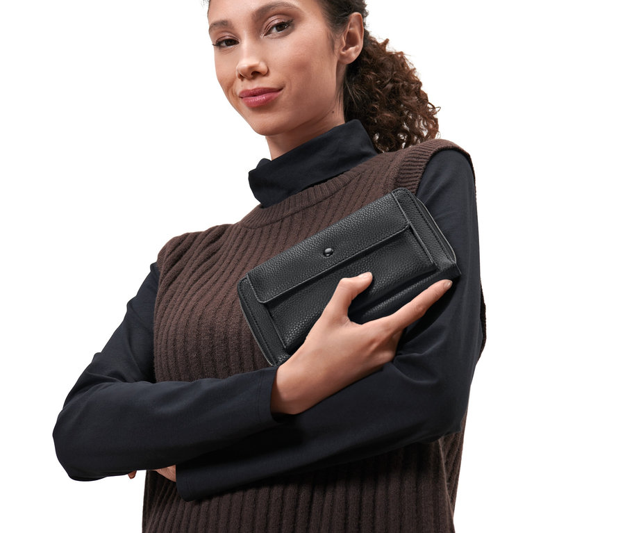 Frau hält eine schwarze Mini-Tasche in der Hand.