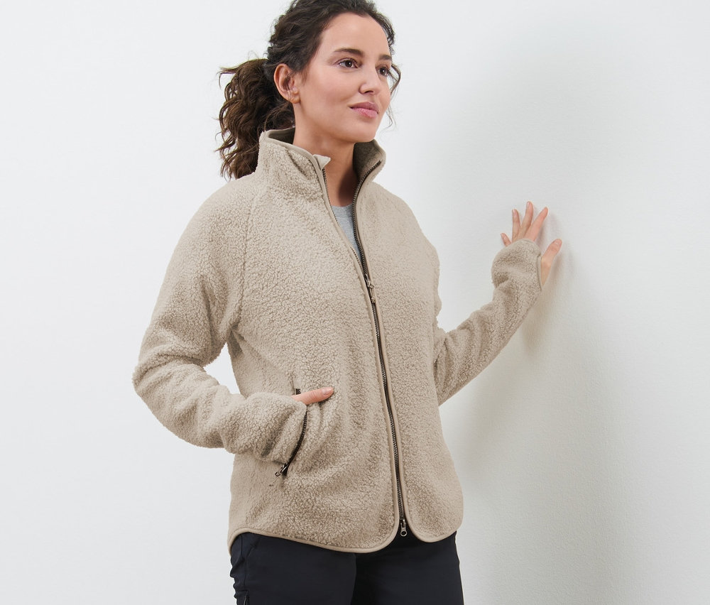 Frau trägt eine beige Teddyfleece-Jacke.