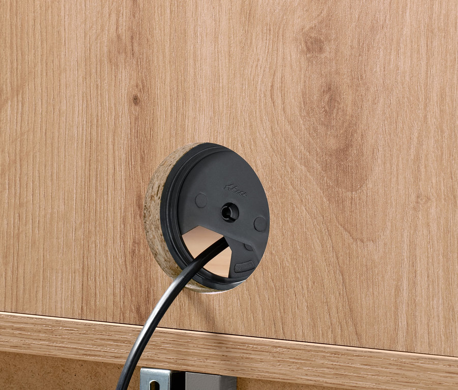 Detailaufnahme einer Kabeldurchführung in einem Highboard mit 2 Türen.