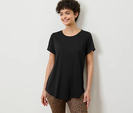 Frau posiert in einem schwarzen Longshirt.