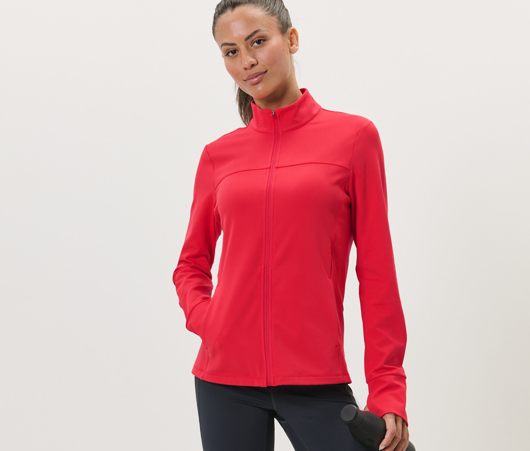 Frau trägt eine rote Sportjacke.