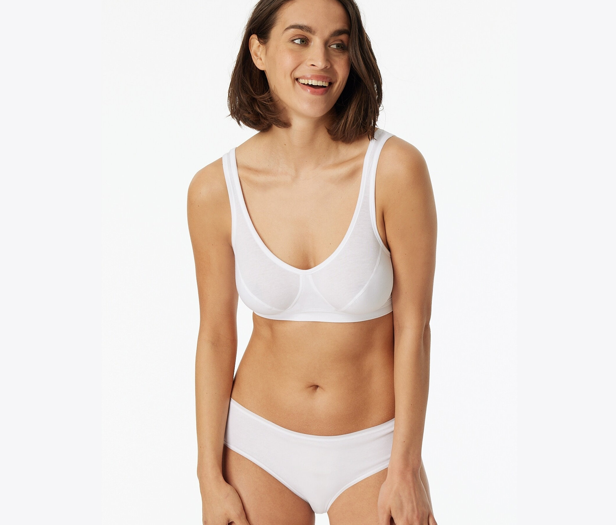Lächelnde Frau trägt einen weißen BH und 2 SCHIESSER Hipster, weiß.