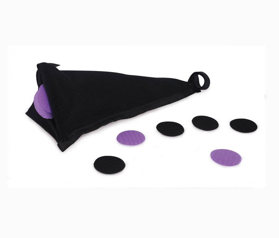 Ein schwarzer Stoffbeutel mit lila und schwarzen Stoffkreisen auf einem weißen Hintergrund.