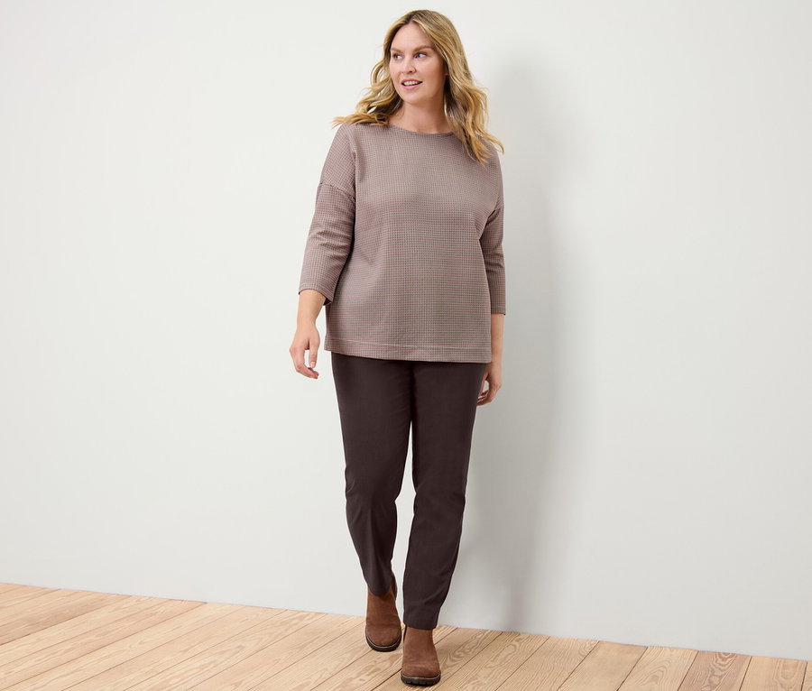 Frau trägt ein kariertes Sweatshirt und eine Bengalin-Hose.