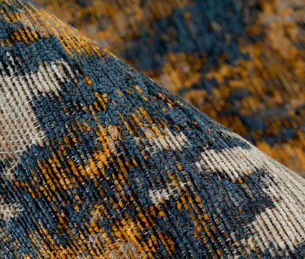 Nahaufnahme eines blau-gelben Kurzflorteppichs.