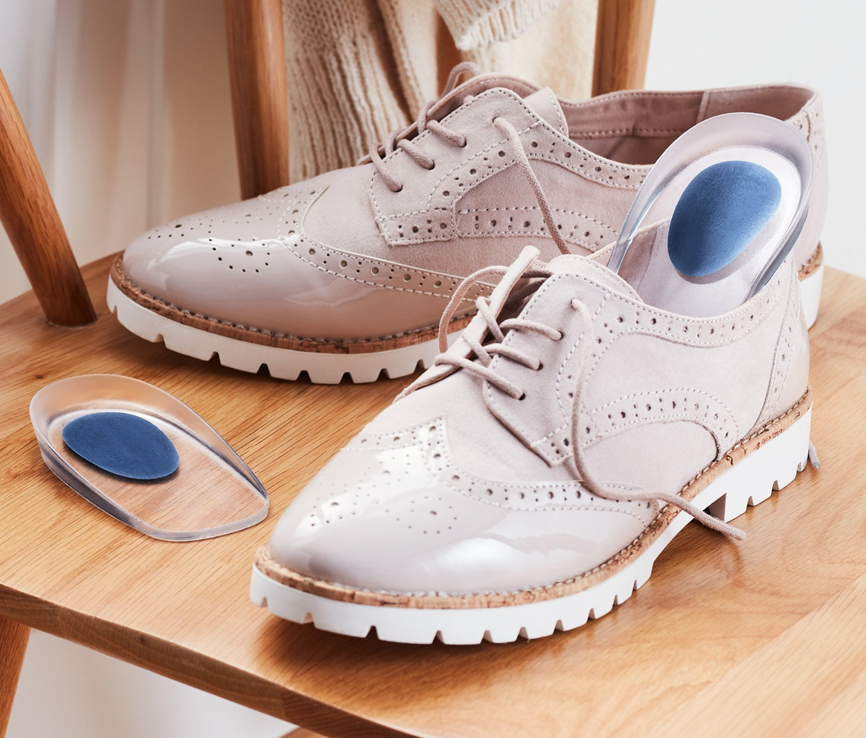 Auf einem Holzstuhl liegen Lackschuhe und 1 Paar Fersenkeile.