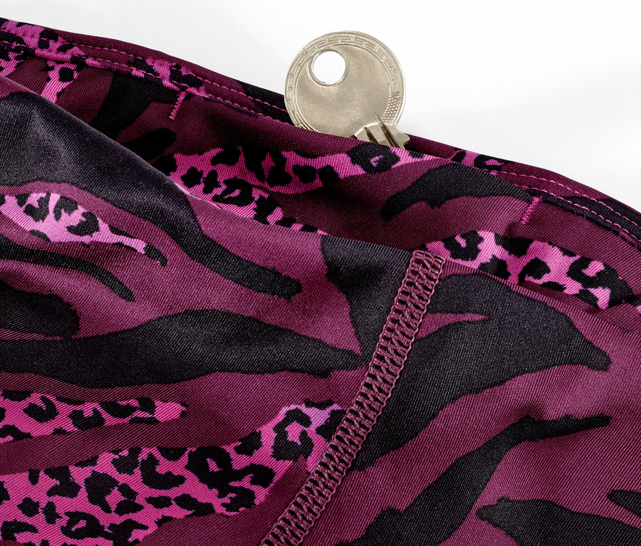 Detail einer lila 3/4-Sporttight mit Alloverprint und einem Schlüssel in der Tasche.
