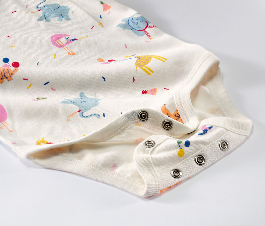 Detailaufnahme von 5 Baby-Bodys mit Mitwachsfunktion und Tiermuster.