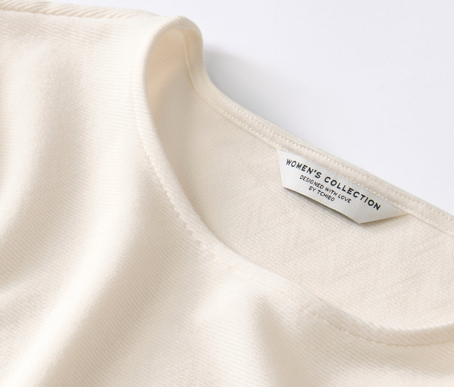 Detailansicht eines cremeweißen Blusenshirts.