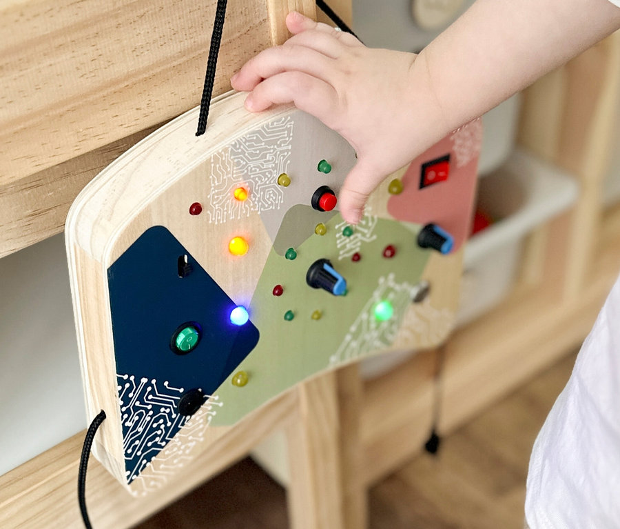 Kind spielt mit small foot Motorikbrett, LED und Schalter.