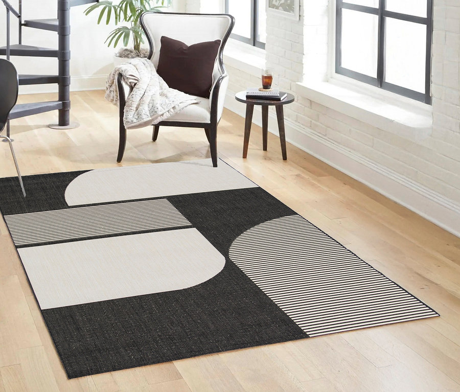 Schwarz-weißer Outdoor-Teppich »Zen Lines« auf Holzboden im Wohnzimmer.