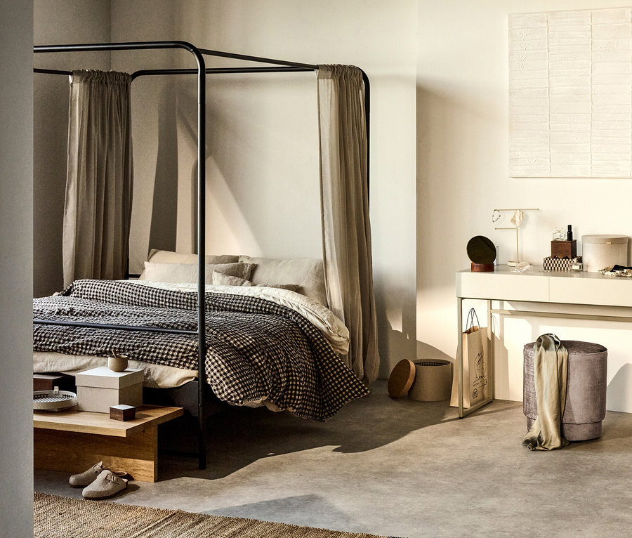Schwarzes Woood Bett »Bunk« 160 x 200 cm mit Überwurf und Vorhängen. Im Zimmer stehen ein Tisch, ein Teppich und ein Schminktisch.